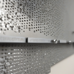 Installation diagram showing how to mount a steel pegboard to concrete wall using anchors