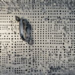 A fully organized garage wall with pegboard holding tools, bins, and shelves